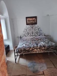 a bedroom with a bed with a metal frame at Trullo martina in Martina Franca