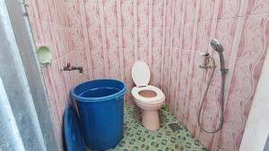 a small bathroom with a toilet and a shower at Labore Homestay in Waha