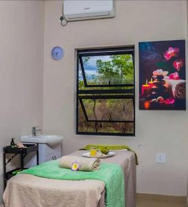 a room with a bed and a sink and a window at Tree Tops Game Resort in Magomba