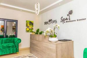 a room with a green couch and a table with flowers at Tree Tops Game Resort in Magomba +45 photos