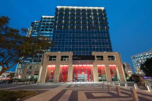 a tall building with red lights in front of it at NYX Tel Aviv in Tel Aviv