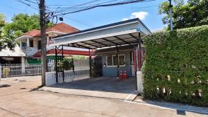 a garage in front of a house with a fence at Living Room Udonthani in Udon Thani
