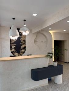 a lobby with a counter with two pendant lights at Small Cozy Spa Hotel in Aktobe