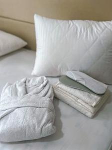 a bed with white towels and a phone on it at Small Cozy Spa Hotel in Aktobe