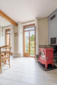 a living room with a red stove and a table at Le gîte embarqué - Géré par Presta-Zen'Services - Barque électrique en supplément in Verdun-sur-Meuse