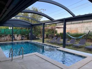 a swimming pool with a pergola and chairs and a swimming poolvisor at Derya Beach Ağullu Villa 2 in Kaş