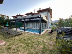 a house with a swimming pool in the backyard at Derya Beach Ağullu Villa 2 in Kaş