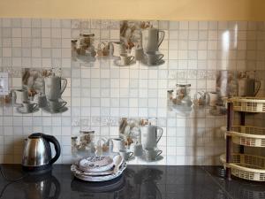 a kitchen with pots and pans on a tiled wall at Aangan by Mom in Kalpa