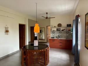 a dining room with a table and a kitchen at Sudama Cityscapes in Cochin