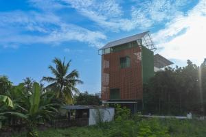 a red brick tower with a blue sky in the background at Sudama Cityscapes in Cochin