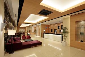 a lobby with a couch and a table in a building at Candeo Hotels Kikuyo Kumamoto Airport in Kikuyo