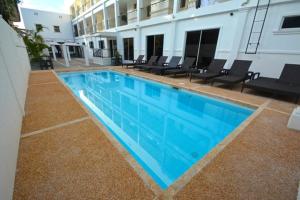 a large swimming pool with chairs and a building at Panglao Regents Park Resort in Panglao Island