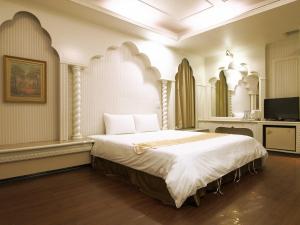 a bedroom with a large bed in a room at Yi Pin Yuan Hotel in Tainan