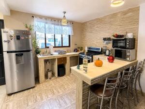 a kitchen with a stainless steel refrigerator and a table at Departamento completo para 6 personas a 3 Min del Estadio Azteca-Banorte y muy cerca de la zona de Hospitales in Mexico City