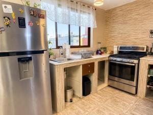 a kitchen with a stainless steel refrigerator and a sink at Departamento completo para 6 personas a 3 Min del Estadio Azteca-Banorte y muy cerca de la zona de Hospitales in Mexico City +28 photos