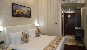 a bedroom with a large white bed with pillows at Hotel Grand Maple in Jaipur +42 photos