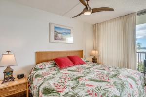 a bedroom with a bed with red pillows and a window at Mana Kai Maui Condo - Right on the Beach! in Wailea