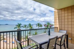 a table and chairs on a balcony with a view of the beach at Mana Kai Maui Condo - Right on the Beach! in Wailea