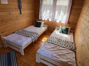 a room with two beds in a log cabin at Domki Letniskowe Kalem in Zabin