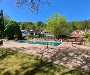 a swimming pool with a group of people sitting around it at Die Heilsbach gGmbH in Fischbach