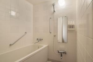 a white bathroom with a tub and a shower at The Alps Hotel Hakuba in Otari +38 photos