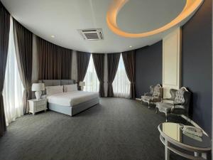 a bedroom with a bed and a table and chairs at Casa Bianca in Kluang