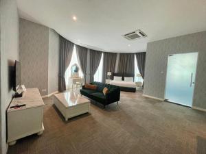 a living room with a couch and a bed at Casa Bianca in Kluang