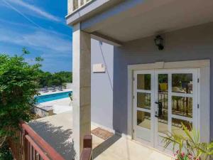 a house with a white door and a view of a pool at Villa Maria in Krnica