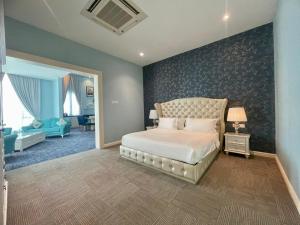 a bedroom with a large bed and a living room at Casa Bianca in Kluang