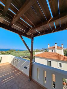 a balcony with a view of a house with a roof at Tompras Village in Paralia Demonias