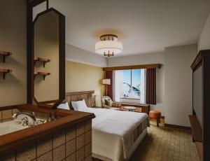 a hotel room with a bed and a sink at The Alps Hotel Hakuba in Otari