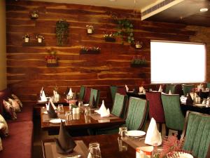 a restaurant with wooden walls and tables and chairs at Hotel Grand Maple in Jaipur