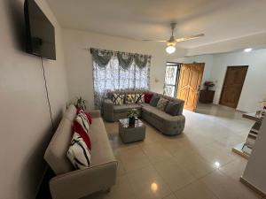 a living room with two couches and a flat screen tv at Central Suites Jaraba in Jarabacoa