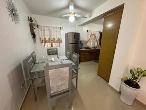 a kitchen with a dining table and a refrigerator at Central Suites Jaraba in Jarabacoa