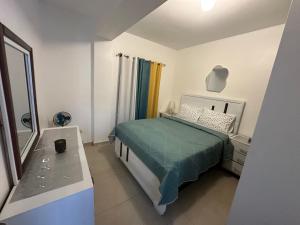 a small bedroom with a bed and a mirror at Central Suites Jaraba in Jarabacoa
