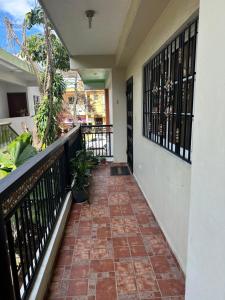a balcony of a house with a tile floor and black railing at Central Suites Jaraba in Jarabacoa
