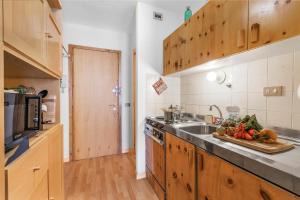 a kitchen with a sink and a counter with vegetables on a cutting board at Studio Sansi 34 - Happy Rentals in Cesana Torinese