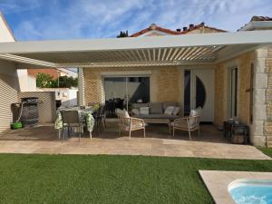 a patio with a couch and a table and chairs at Maison individuelle piscine extérieure in Port-Saint-Louis-du-Rhône