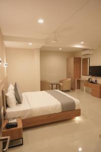 ein Schlafzimmer mit einem großen Bett und ein Wohnzimmer in der Unterkunft Hotel D' Paris in Kozhikode