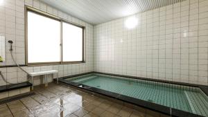 a swimming pool in a bathroom with a window at Suzuka Storia Hotel in Suzuka