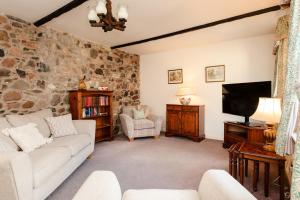 a living room with a couch and a flat screen tv at Bramble Cottage in Wooler