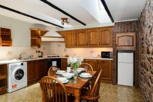 a kitchen with a wooden table with chairs and a sink at Bramble Cottage in Wooler