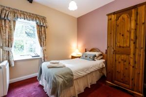 a bedroom with a bed and a window at Fern Cottage in Wooler +42 photos