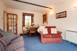 a living room with a table and a couch and a chair at Blueberry Cottage in Wooler