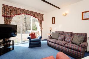 a living room with a couch and a tv at Blueberry Cottage in Wooler
