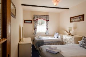 a bedroom with two beds and a window at Blueberry Cottage in Wooler +41 photos