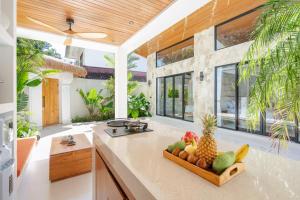 a kitchen with a island with a bowl of fruit on the counter at Harbie Villa in Seminyak