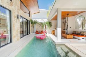 an indoor pool with a pink inflatable pool noodle in a house at Harbie Villa in Seminyak