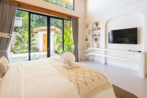 a bedroom with a large bed and a large window at Harbie Villa in Seminyak +21 photos