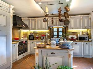 a kitchen with white cabinets and a counter with pots and pans at Villa With Pool, Gym, Pond And Panoramic Views in Laterina